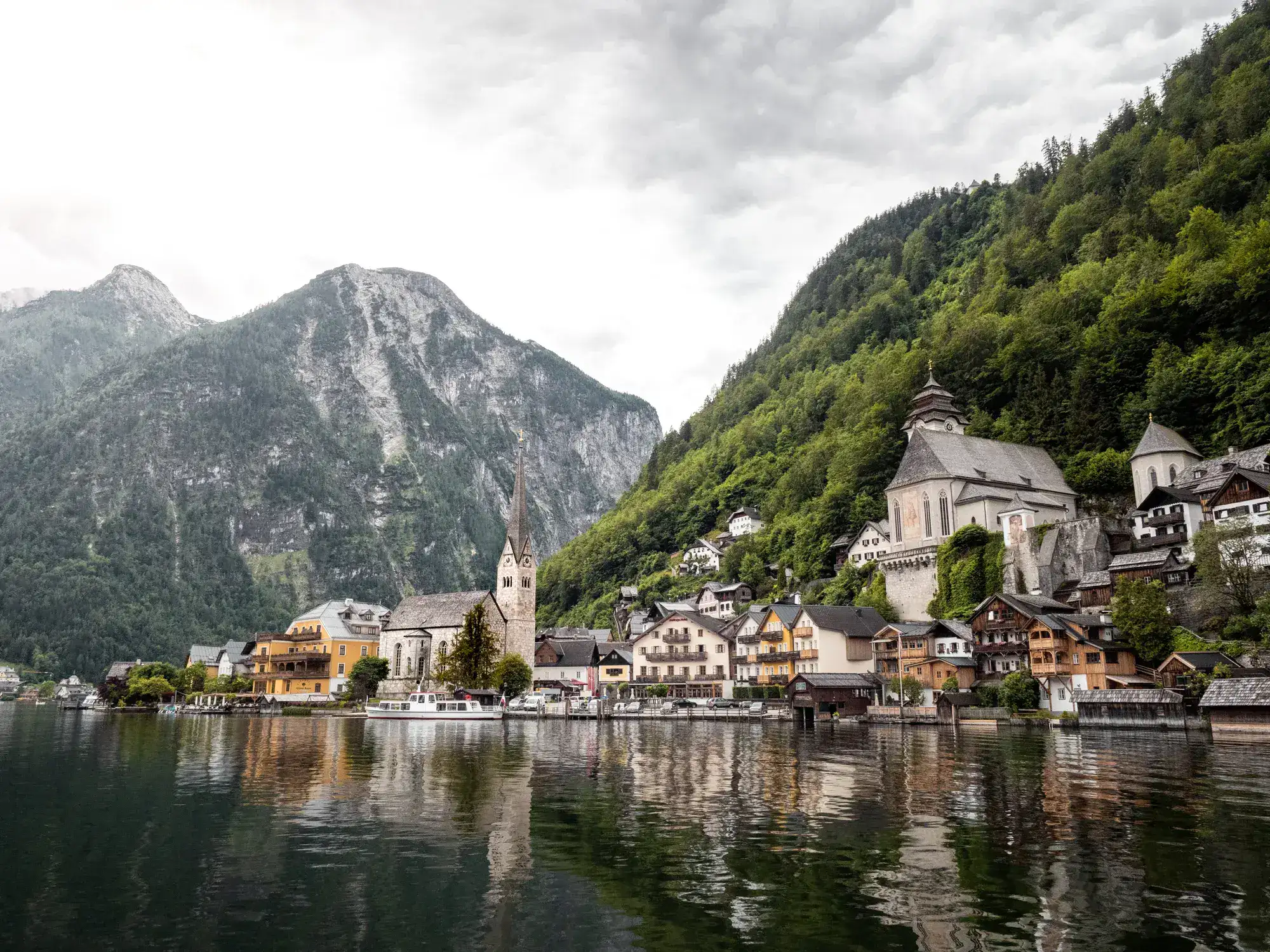 Hallstatt, with the idyllic view of the church tower, the lake, and the mountains in the background.