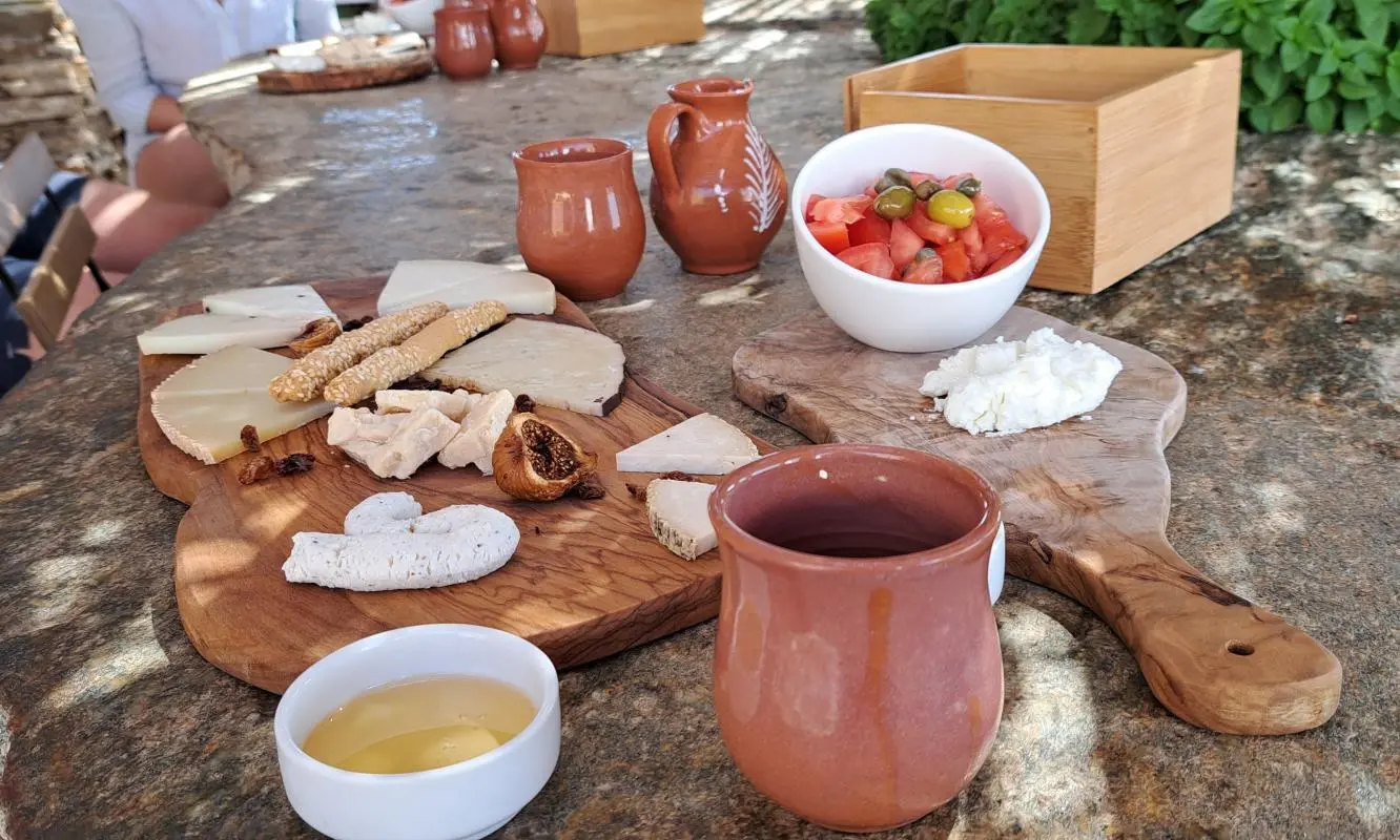 cheese served on a wooden platter, accompanied by a tomato salad