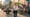 Young professional with laptop bag in Wynwood Miami, passing murals and outdoor workers with laptops